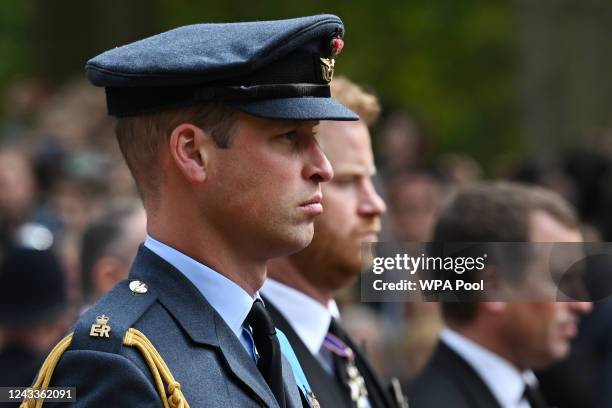 Prince William, Prince of Wales and Britain's Prince Harry, Duke of Sussex follow the coffin of Queen Elizabeth II, draped in the Royal Standard, as...