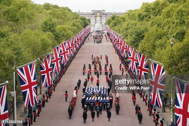 The State Gun Carriage carries the coffin of Queen Elizabeth II, draped in the Royal Standard with the Imperial State Crown and the Sovereign's orb...