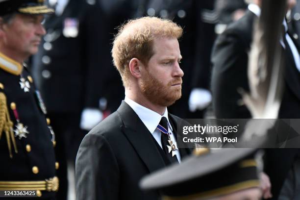 Prince Harry, Duke of Sussex, follows the coffin of Queen Elizabeth II, draped in the Royal Standard, on the State Gun Carriage of the Royal Navy, as...