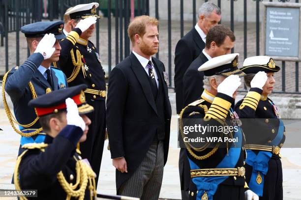 Britain's Prince Harry, Duke of Sussex, stands next to King Charles, Anne, Princess Royal, and William, Prince of Wales, as they salute during the...