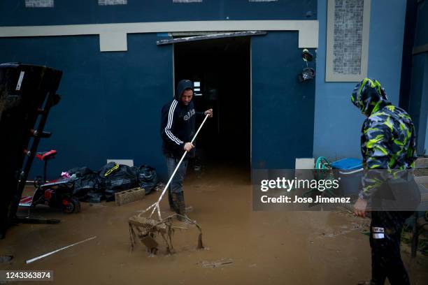 Members of the Nevares remove the mud from their home after La Plata river overflooded and their two-story house was almost completely submerged on...