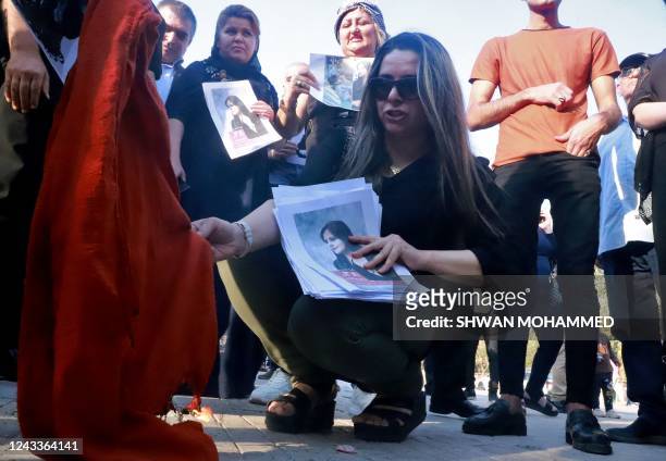 Woman sets a headscarf on fire as Iraqi and Iranian Kurds, residing in northern Iraq, protest near a park in the Iraqi Kurdish city of Sulaimaniya on...