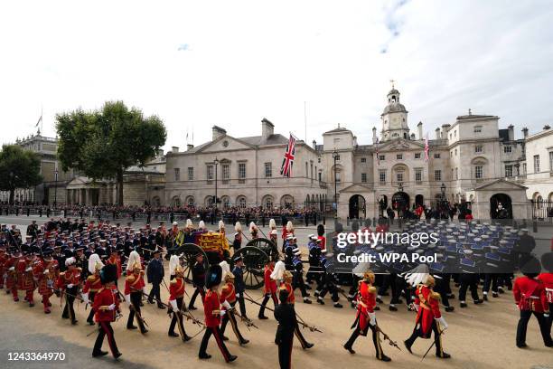 The State Gun Carriage carries the coffin of Queen Elizabeth II, draped in the Royal Standard with the Imperial State Crown and the Sovereign's orb...