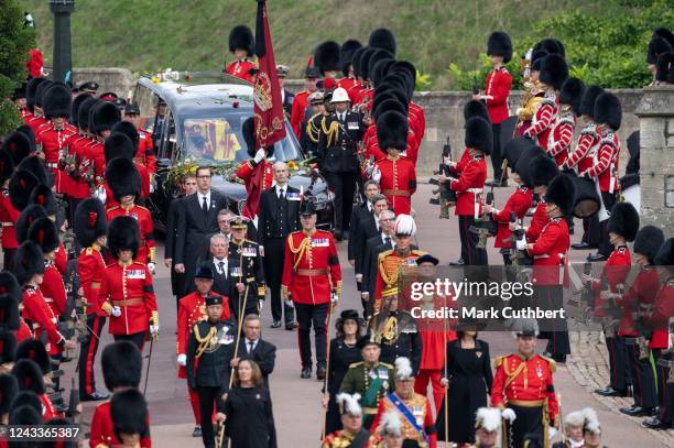 The coffin of Queen Elizabeth II is carried in The state hearse as it proceeds towards St. George's Chapel followed by Prince Edward, Earl of Wessex,...