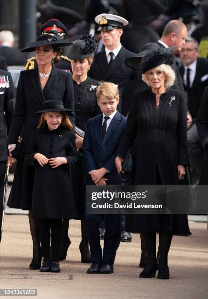 Catherine, Princess of Wales, Princess Charlotte of Wales, Prince George of Wales and Camilla, Queen Consort watch the coffin of Queen Elizabeth II...