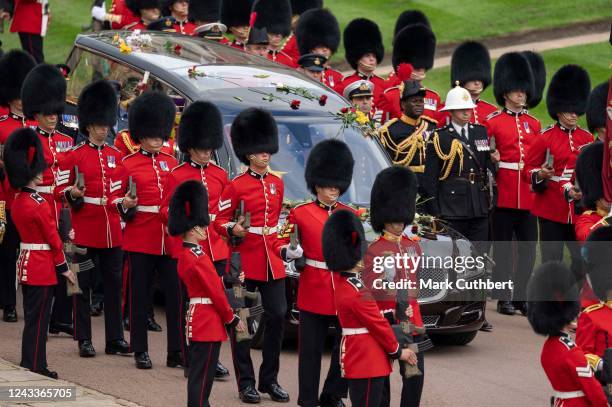 The coffin of Queen Elizabeth II is carried in The state hearse as it proceeds towards St. George's Chapel followed by Prince Edward, Earl of Wessex,...