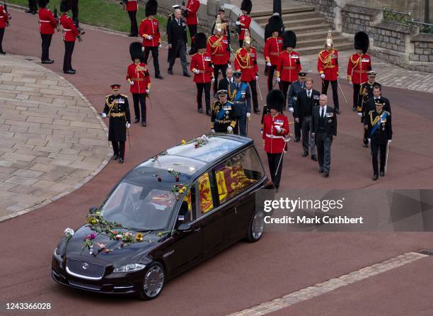 The coffin of Queen Elizabeth II is carried in The state hearse as it proceeds towards St. George's Chapel followed by Prince Edward, Earl of Wessex,...