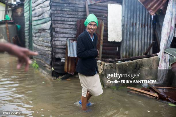 Woman wades through a flooded street in Nagua, Dominican Republic, on September 19 after the passage of Hurricane Fiona. - Hurricane Fiona slammed...