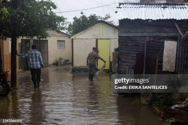 Men wade through a flooded street in Nagua, Dominican Republic, on September 19 after the passage of Hurricane Fiona. - Hurricane Fiona slammed into...