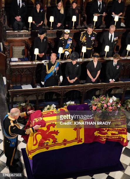 King Charles III places the the Queen's Company Camp Colour of the Grenadier Guards on the coffin at the Committal Service for Britain's Queen...