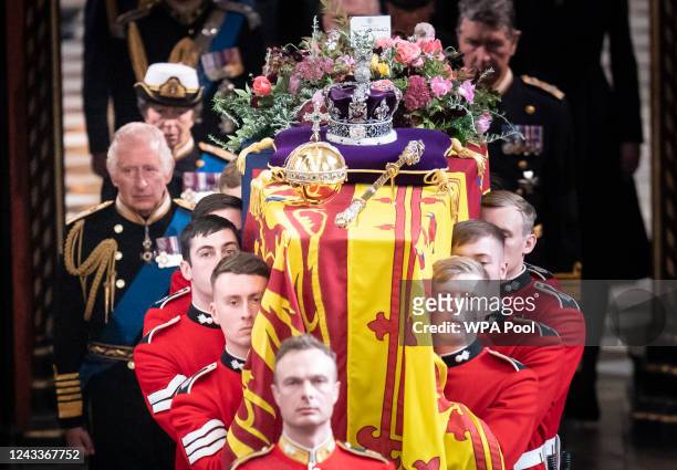 King Charles III follows behind the coffin of Queen Elizabeth II, draped in the Royal Standard with the Imperial State Crown and the Sovereign's orb...