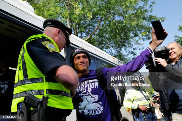 Martha's Vineyard, MA Carlos, a Venezuelan migrant, waves to volunteers before boarding a bus to the Vineyard Haven ferry terminal outside of St....