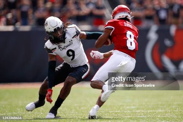 Miami Redhawks running back Kevin Davis carries the ball with Cincinnati Bearcats cornerback Arquon Bush defending during the game against the Miami...