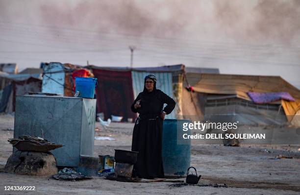 Syrian woman smokes a cigarette at the Sahlah al-Banat camp for displaced people in the countryside of Raqa, in northern Syria, on September 19,...