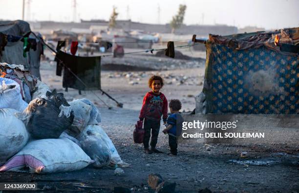 Syrian girl carries a water container at the Sahlah al-Banat camp for displaced people in the A countryside of Raqa, in northern Syria, on September...