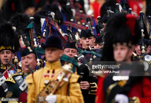 Pipers playing while leading the State Hearse carries the coffin of Queen Elizabeth II, draped in the Royal Standard with the Imperial State Crown...