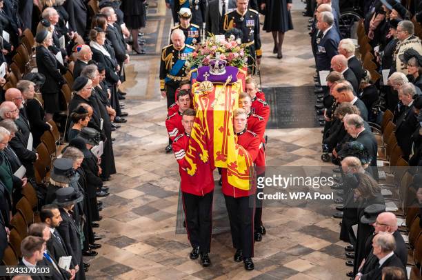 King Charles III follow behind the coffin of Queen Elizabeth II, draped in the Royal Standard with the Imperial State Crown and the Sovereign's orb...