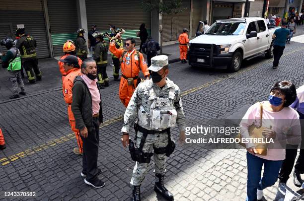 Firefighters and rescuers look at damages in a building after an eartquake in Mexico City on September 19, 2022. - A powerful earthquake struck...