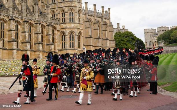 Pipers playing while leading the State Hearse carries the coffin of Queen Elizabeth II, draped in the Royal Standard with the Imperial State Crown...
