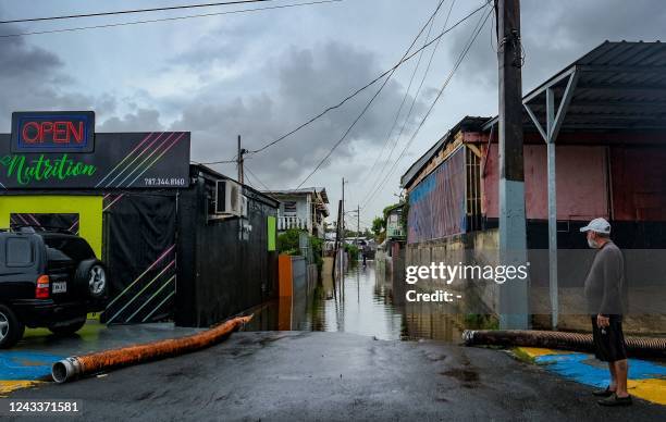 Man looks at a flooded street in the Juana Matos neighborhood of Catano, Puerto Rico, on September 19 after the passage of Hurricane Fiona. -...