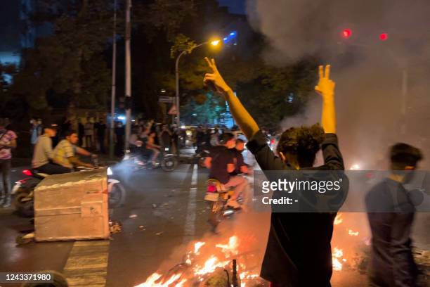 Picture obtained by AFP outside Iran shows shows a demonstrator raising his arms and makes the victory sign during a protest for Mahsa Amini, a woman...