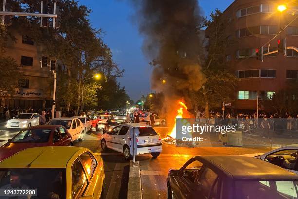 Picture obtained by AFP outside Iran shows a motorbike burning in the middle of an intersection during protests for Mahsa Amini, a woman who died...