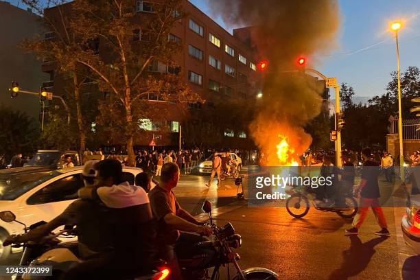 Picture obtained by AFP outside Iran shows demonstrators gathering around a burning barricade during a protest for Mahsa Amini, a woman who died...