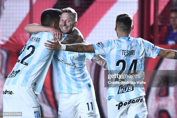 Cristian Menendez of Atletico Tucuman celebrates with teammates Joaquin Pereyra and Renzo Tesuri after scoring the second goal of his team during a...
