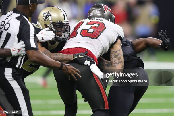 Tampa Bay Buccaneers wide receiver Mike Evans reacts to the New Orleans Saints defensive backs Marcus Maye as Marshon Lattimore grabs Evans from...