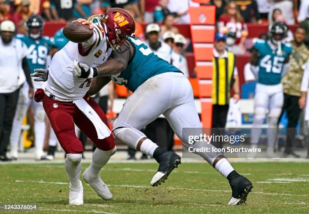September 11: Washington Commanders quarterback Carson Wentz tries to avoid a sack by Jacksonville Jaguars defensive tackle Folorunso Fatukasi during...