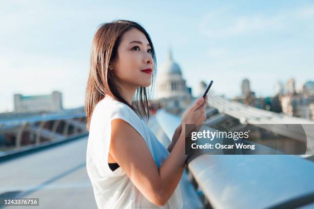 successful businesswoman on the go in financial district - japanese woman looking up stock pictures, royalty-free photos & images