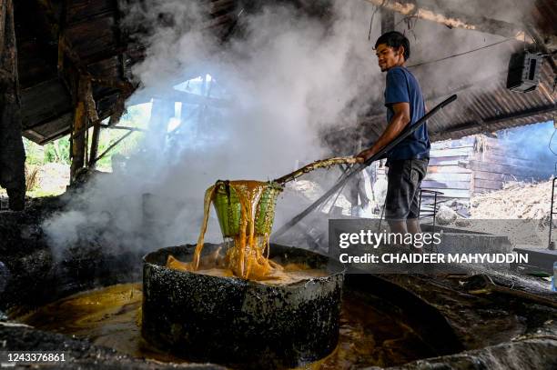 This photo taken on September 19, 2022 shows a worker cooking sugar cane to produce brown sugar at a home industry in Ketol, central of Aceh province.