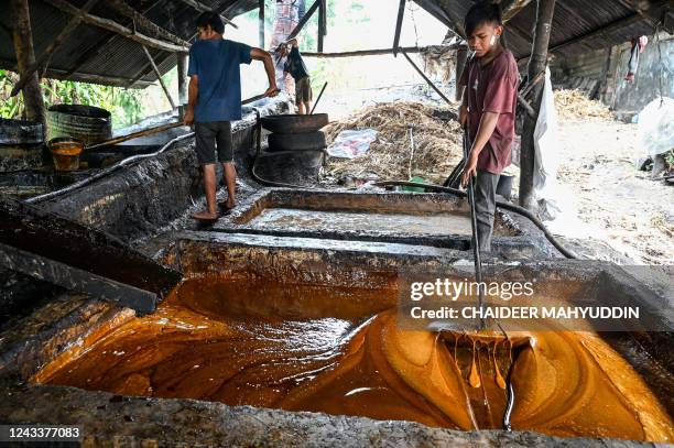 This photo taken on September 19, 2022 shows workers cooking sugar cane to produce brown sugar at a home industry in Ketol, central of Aceh province.