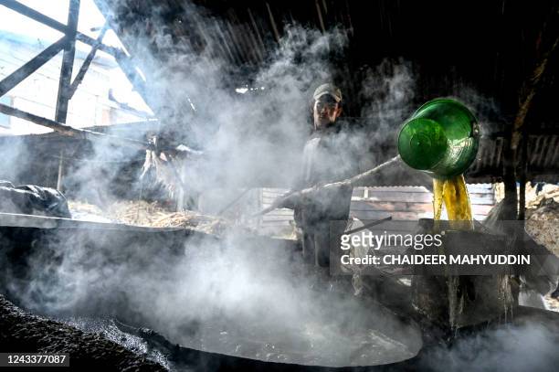 This photo taken on September 19, 2022 shows a worker cooking sugar cane to produce brown sugar at a home industry in Ketol, central of Aceh province.