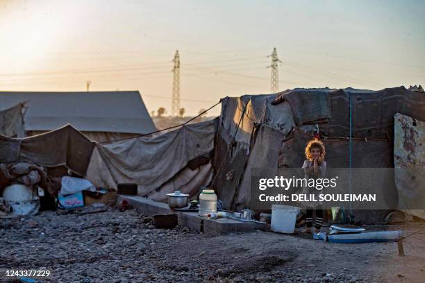 Syrian children sit outside a tent at the Sahlah al-Banat camp for displaced people in the countryside of Raqa, in northern Syria, on September 19,...