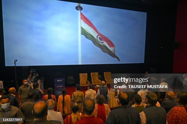 Guests stand as India's national anthem is played inside a multiplex cinema during its inauguration ceremony in Srinagar on September 20, 2022.