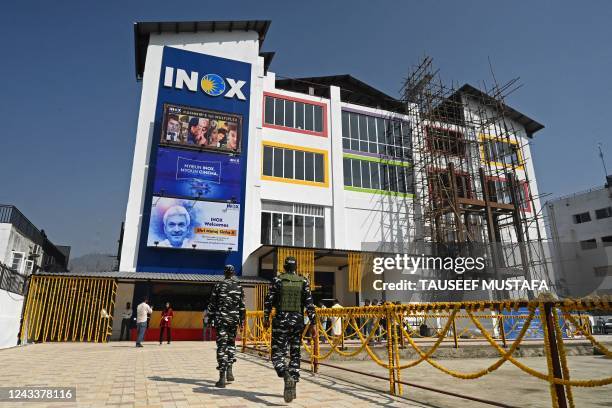 Indian paramilitary troopers walk in front of a multiplex cinema during its inauguration ceremony in Srinagar on September 20, 2022.