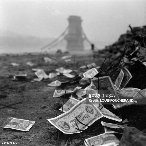 Hungarian banknotes lie on the ground on the banks of the Danube near the destroyed Chain Bridge in Budapest, in January 1946, during the...