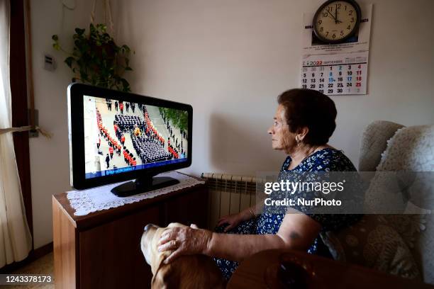 An elderly woman watches the State Funeral of Queen Elizabeth II live on Spanish TV, held at Westminster Abbey, on September 19, 2022 in London...