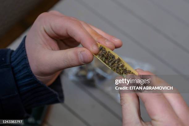 Person rolls a joint with illegally purchased marijuana in Montevideo, on August 18, 2022 - In 2013, Uruguay made history when it became the first...