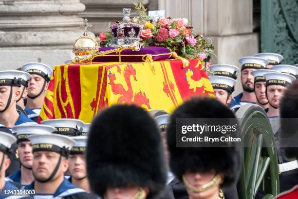 The imperial state crown, the sovereign's orb, the sovereign's sceptre sit on top of the Queen Elizabeth II coffin as Royal Navy sailors pull the gun...