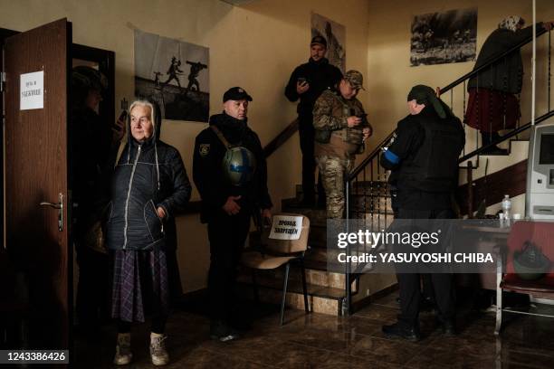 Woman waits to be evacuated, at the local civil administration office in the retaken town of Kozacha Lopan, Kharkiv region, on September 20, 2022. -...