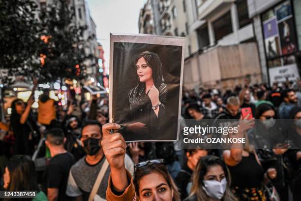 Protester holds a portrait of Mahsa Amini during a demonstration in support of Amini, a young Iranian woman who died after being arrested in Tehran...