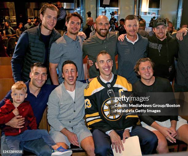 September 20: Boston Bruins players including, Patrice Bergeron, holding his son Zack, Brad Marchand and Charlie McAvoy pose with Zdeno Chara,...