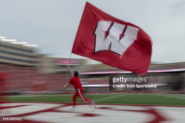 Wisconsin Badger Cheerleader carries the motion W flag across the endzone after a touchdown durning a college football game between the New Mexico...