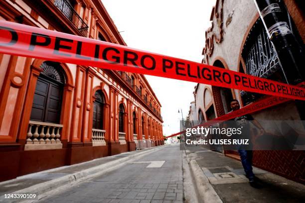 Man walks past a cordon-off area affected after yesterday's earthquake in Colima, state of Colima, Mexico, on September 20, 2022. - Two people were...