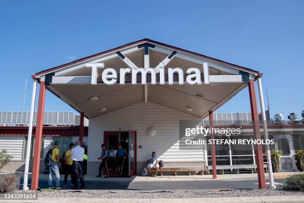 Volunteers with SAMU and police officers stand outside Delaware Coastal Airport in Georgetown, Delaware, on September 20, 2022. - A plane of mainly...