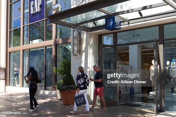 People leave the Gap retail store after shopping on September 20, 2022 in Los Angeles, California. Gap Inc. Is set to cut about 500 corporate jobs as...