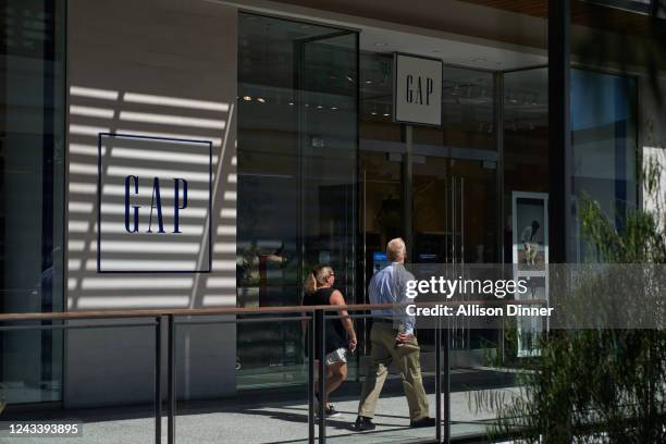 People walk by the Gap retail store in Century City on September 20, 2022 in Los Angeles, California. Gap Inc. Is set to cut about 500 corporate jobs...