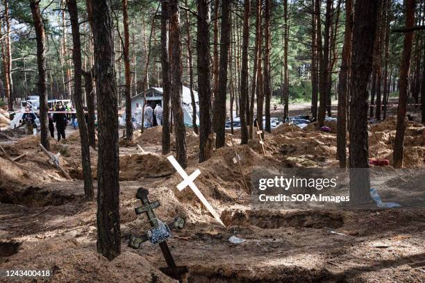 Cross at the site of a mass grave during exhumation in the town of Izium, recently liberated by the Ukrainian Armed Forces, in the Kharkiv region....